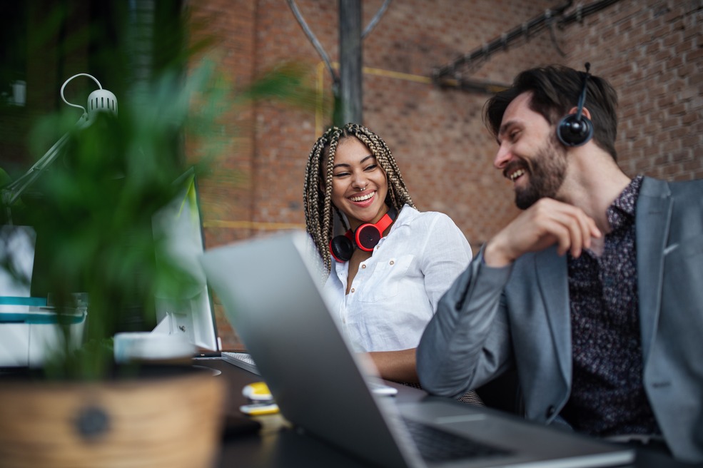 cheerful-young-businesspeople-sitting-and-working