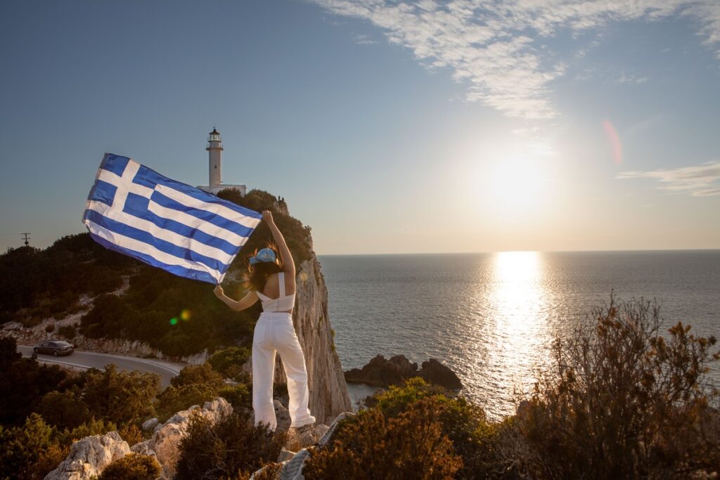 woman-with-greece-flag-looking-at-sunset-above-the-2025