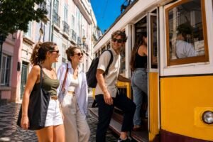 Jeunes amis souriants montant dans le tramway 28 de Lisbonne sous le soleil